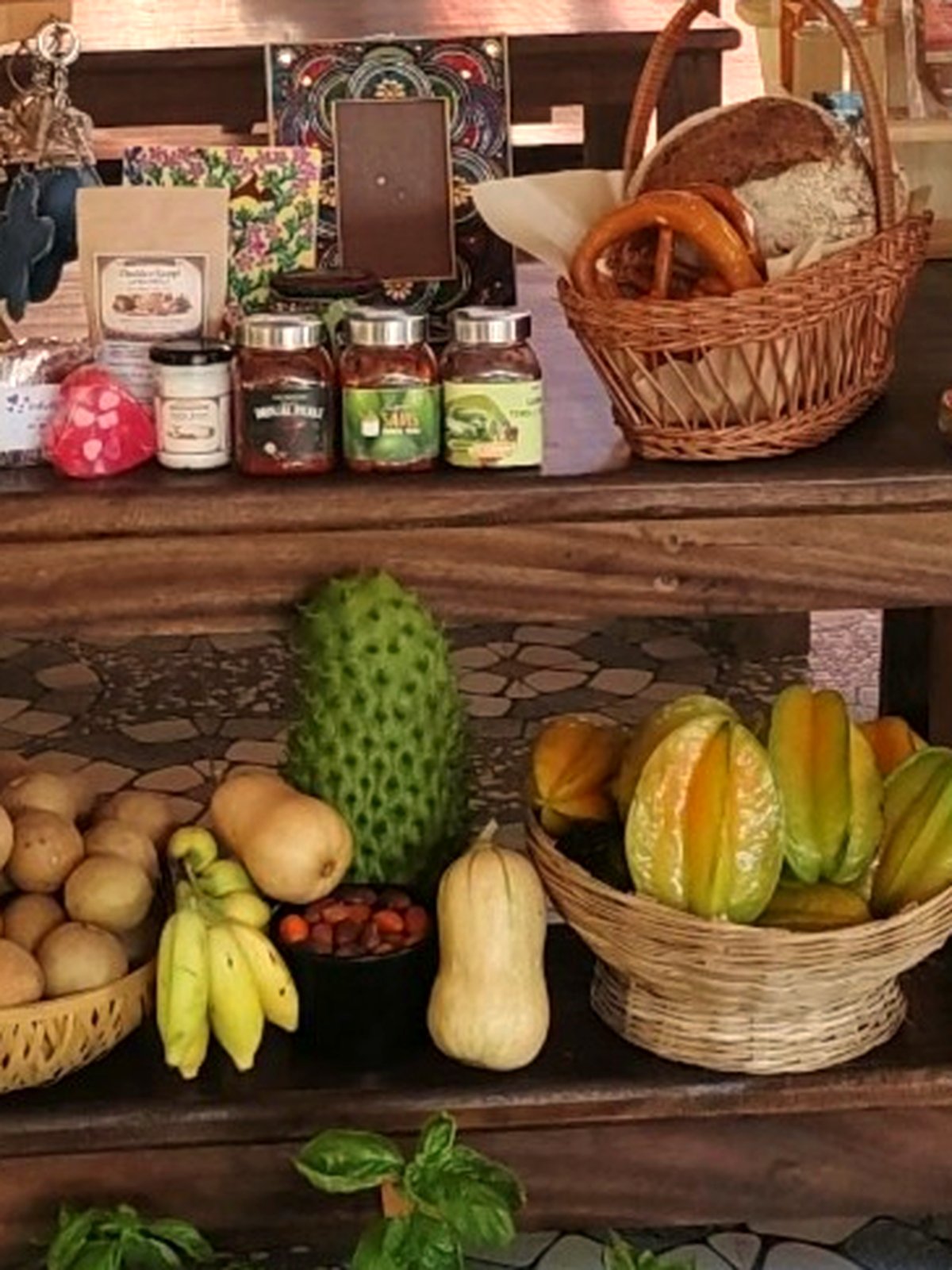 A market table laid with seed packets, jars of preserves, baskets of fruit and vegetables